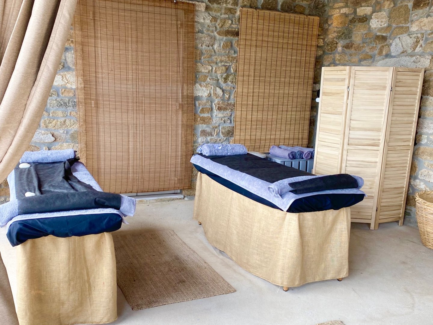 Outdoor massage area at spa with two massage couches set up with towels