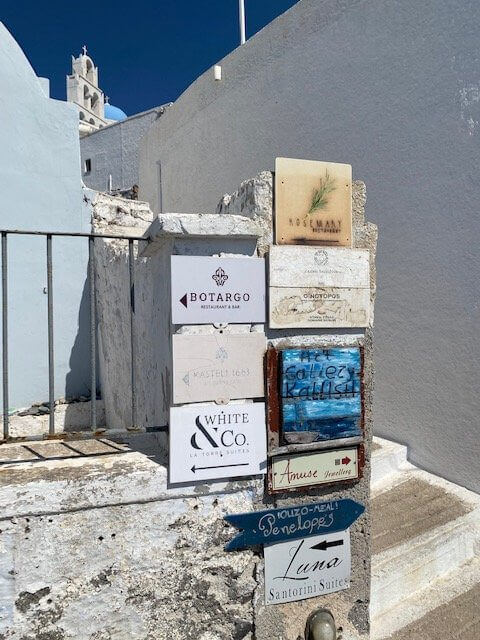 signs on a wall with arrows to various restaurants and businesses