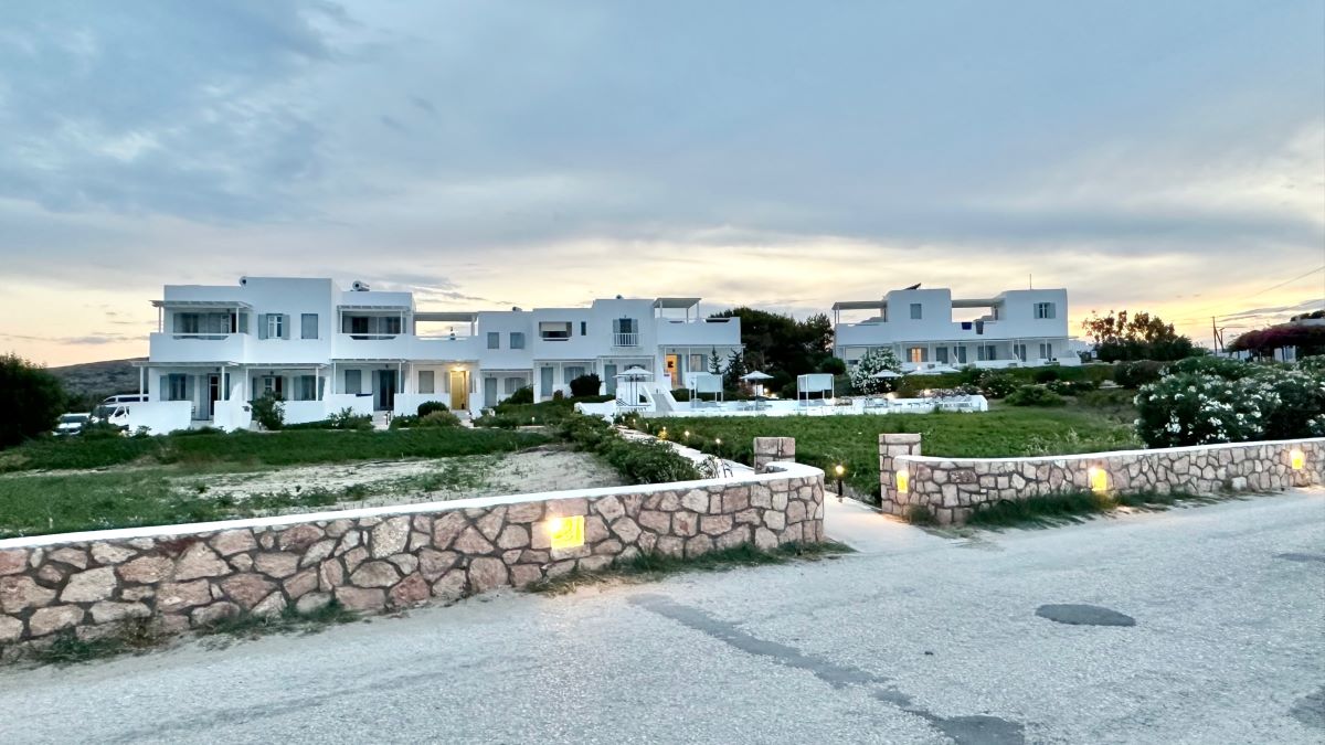 White, cubed buildings of a hotel set back from the road