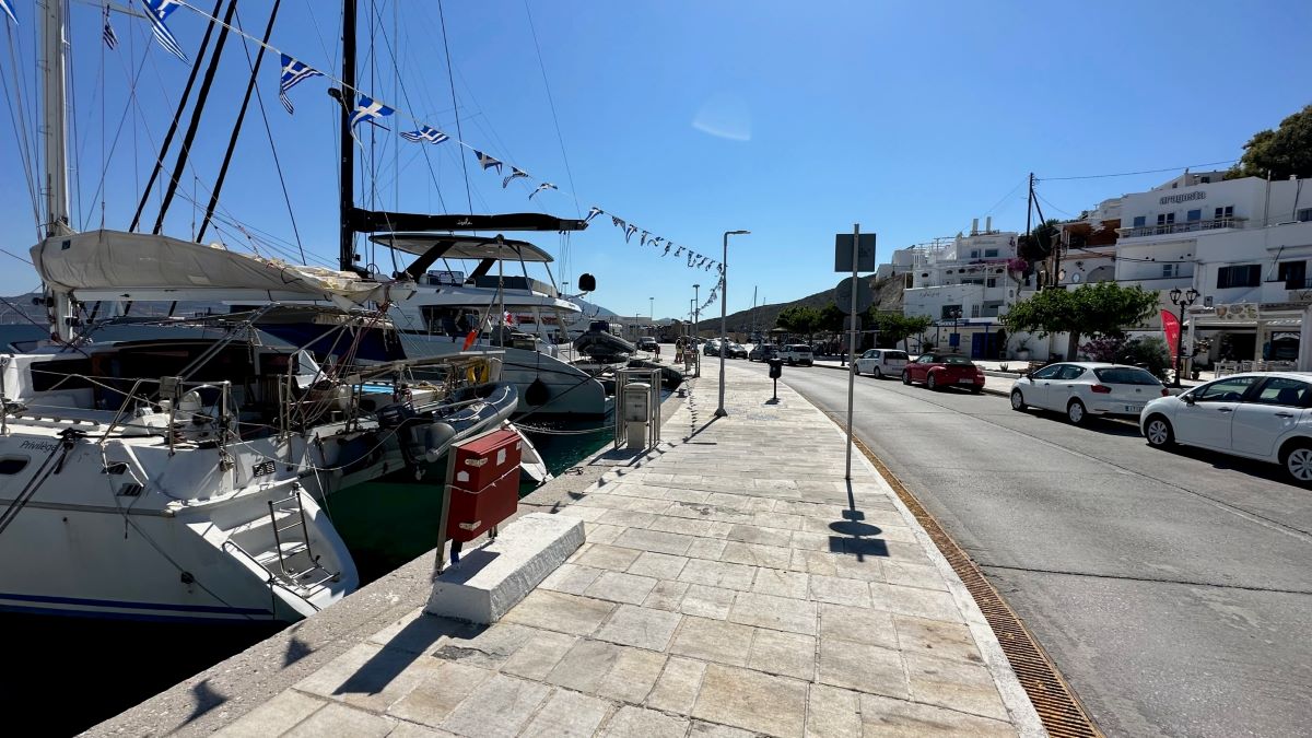 Adamas Port with boats in the harbour beside the main road