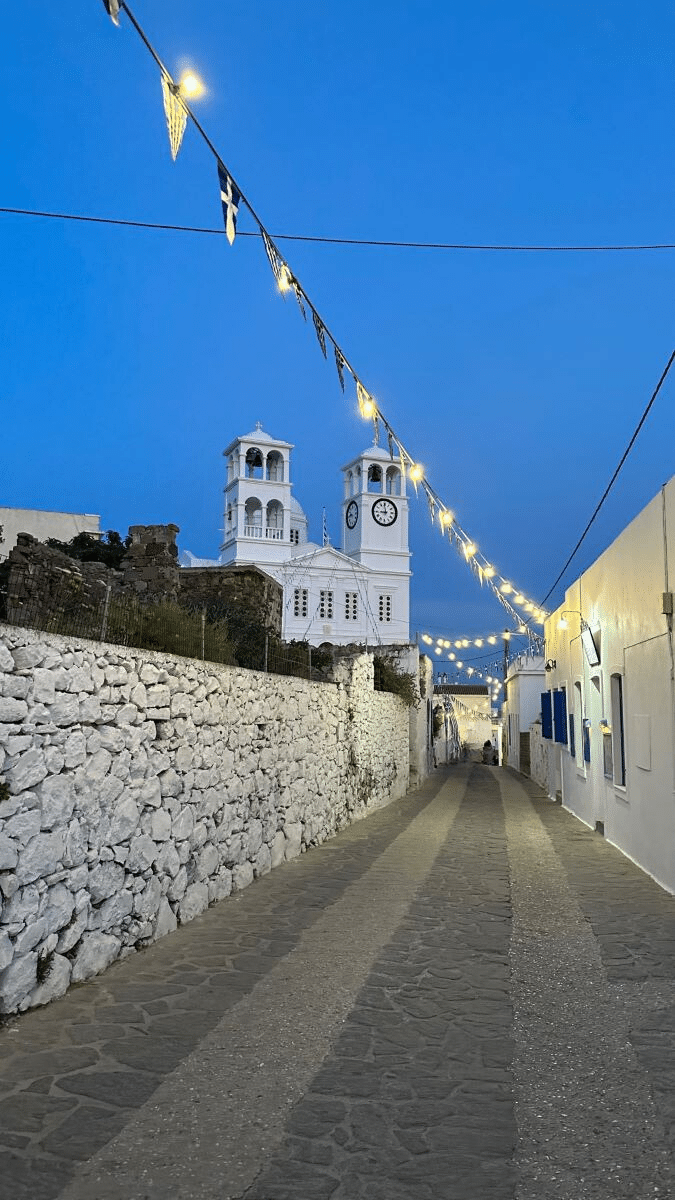 Narrow street in Trypiti village Milos with church and lanterns